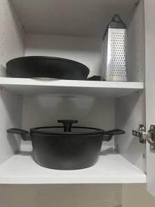 uno scaffale con due pentole e padelle in una cucina di Amazing apartment in the center a Salonicco