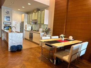 uma cozinha e sala de jantar com mesa e cadeiras em Cozy Straits Quay Seafront Suite em Tanjong Tokong