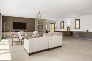 sala de estar con muebles blancos y TV de pantalla plana en Villa Valériane, en Trans-en-Provence