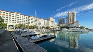 Tanjong Tokong的住宿－Cozy Straits Quay Seafront Suite，码头,码头旁有船在水中