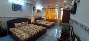 Habitación de hotel con 2 camas y TV en Huynh Lac Can Tho Hotel, en Can Tho