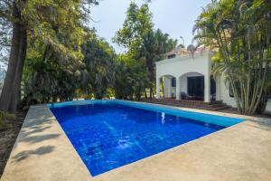uma piscina em frente a uma casa com árvores em Citrus County, Hoshiarpur, amã Stays & Trails em Hoshiārpur