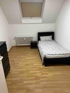 a bedroom with a bed and a wooden floor at Gemütliche Stadtoase in Weingarten