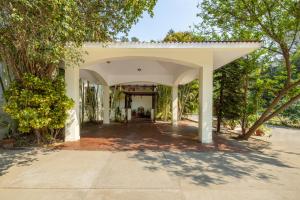 un arco que conduce a un edificio con árboles en Citrus County, Hoshiarpur, amã Stays & Trails, en Hoshiārpur