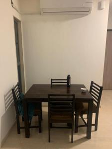 uma mesa de jantar com quatro cadeiras e uma mesa em Room in Flat with Amazing City and Sea View em Mumbai