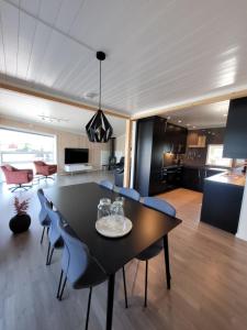 uma sala de jantar e sala de estar com mesa e cadeiras em Moderne rorbu i Lofoten, Vestvågøy em Gravdal