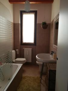 een badkamer met een bad, een toilet en een wastafel bij Accogliente appartamento in cascina lombarda in Segrate