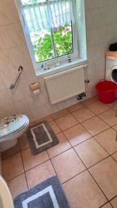 a bathroom with a window and a sink and a toilet at Ferienwohnung Margrit in Detern