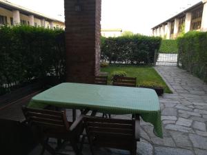 een tafel en stoelen met een groene tafelkleed erop bij Accogliente appartamento in cascina lombarda in Segrate