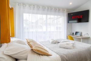 um quarto com 2 camas com lençóis brancos e uma janela em Soleil d'Été - Netflix & Wifi - Balcon - Parking Gratuit - check-in 24H24 - GoodMarning em Châlons-en-Champagne