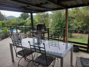 a white table with chairs and a sewing machine on a patio at Maison individuelle, La Miloune in Le Val