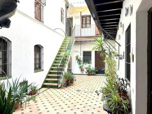 una escalera que conduce a un edificio con macetas en Hispalis mercado de Triana, en Sevilla