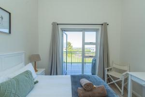 Un dormitorio con una cama con una toalla. en P7 - Goose Valley - Ocean Views, en Plettenberg Bay