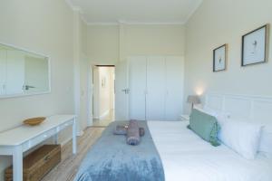 a white room with a bed and a desk at P7 - Goose Valley - Ocean Views in Plettenberg Bay