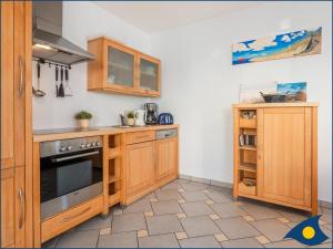 uma cozinha com armários de madeira e um fogão em Villa Bella Whg 09 em Ahlbeck