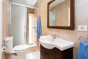 a bathroom with a sink and a toilet and a mirror at La Casita de la Playa in Igueste