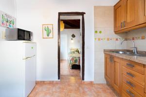 a kitchen with a sink and a refrigerator at La Casita de la Playa in Igueste +36 photos