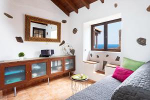 a living room with a couch and a mirror at La Casita de la Playa in Igueste