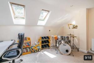 a music room with a desk and drums in it at The Fairways, St Bernard’s Road in Olton