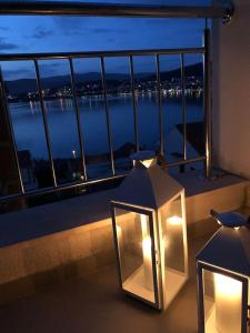 two lights on a balcony with a view of the water at AC apartment in Okrug Gornji