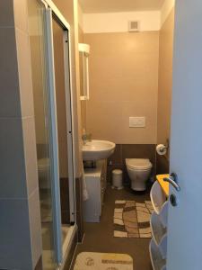 a bathroom with a sink and a toilet and a shower at AC apartment in Okrug Gornji