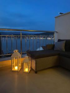a patio with a couch and lights on a balcony at AC apartment in Okrug Gornji