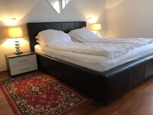 a large bed in a room with two lamps and a rug at AC apartment in Okrug Gornji