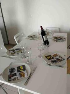 a white table with glasses and a bottle of wine at AC apartment in Okrug Gornji