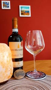 een fles wijn en een wijnglas op een tafel bij L'Incanto del Borgo Antico- Locazione Turistica in Bari