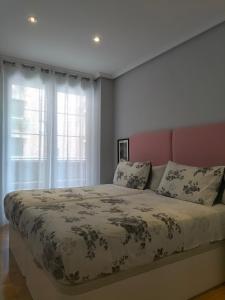 a bedroom with a large bed and a window at Apartamento Virgen del Carmen in Santoña