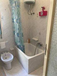 a bathroom with a bath tub and a toilet at Casa della nonna Marina in Floridia