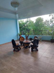 een kamer met stoelen, een tafel en een balkon bij D'Ru Guest House in Labuan Bajo