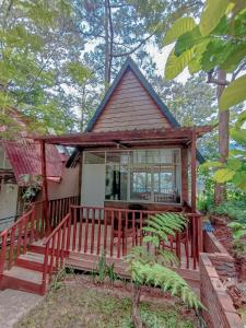 ein kleines Haus mit einer roten Terrasse im Wald in der Unterkunft Pijar Resort Powered by Cocotel 
