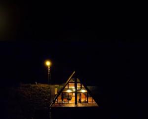 ein Haus mit einer Lampe darüber in der Nacht in der Unterkunft BULUT BUNGALOW in Akcaabat