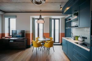 une cuisine avec des placards bleus et une table avec des chaises jaunes dans l'établissement The July - Boat & Co, à Amsterdam