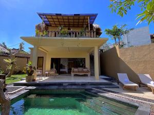 a house with a swimming pool in front of a house at Visakha Sanur in Sanur