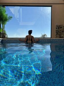 a woman is sitting in a swimming pool at צימר בוטיק אדלה Zimmer boutique adela in Arad