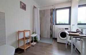 cocina con lavadora en una habitación en Maison avec Piscine intérieure privée sans vis à vis chauffée toute l année, en Quiévrecourt