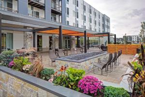 a patio with a pool and some chairs and flowers at Courtyard by Marriott Appleton Riverfront in Appleton