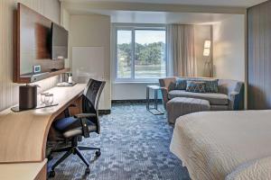a hotel room with a bed and a desk at Courtyard by Marriott Appleton Riverfront in Appleton