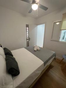 een slaapkamer met een groot wit bed en een plafondventilator bij Casa centro old town in Estepona