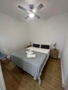 een slaapkamer met een bed met een plafondventilator bij Casa centro old town in Estepona +2 foto's