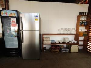 eine Küche mit einem Kühlschrank und einem Regal mit Geschirr in der Unterkunft 89 Villas in El Nido
