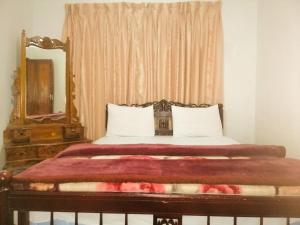 una camera da letto con un letto con specchio e una finestra di Glenfall Guest a Nuwara Eliya