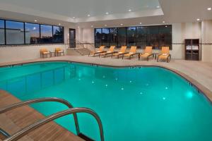 una piscina in un hotel con sedie e tavolo di Courtyard by Marriott Philadelphia City Avenue a Philadelphia