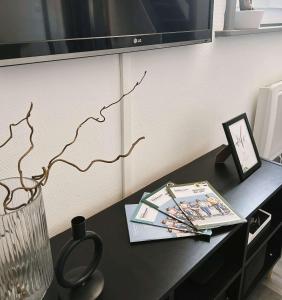 a black table with a tv on a wall at Cosy Dunkerquois in Dunkerque +2 photos