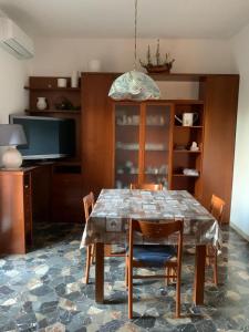 comedor con mesa con sillas y TV en Comfortable apartament 2 bedroom suitable 2-5 pax, en Bolonia