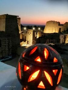 een gesneden Halloween pompoen bovenop een gebouw bij Shahhat House in Luxor