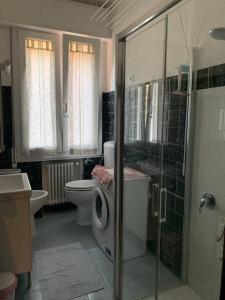 y baño con ducha, aseo y lavamanos. en Comfortable apartament 2 bedroom suitable 2-5 pax, en Bolonia