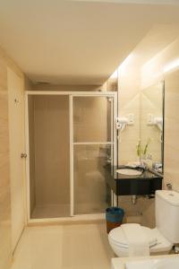 a bathroom with a shower and a toilet and a sink at Hotel Sentral Riverview Melaka in Malacca